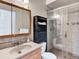Bathroom featuring a vanity, toilet, and tiled shower with glass door at 431 N Harlan St, Lakewood, CO 80226