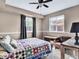 Cozy bedroom with a colorful quilt on the bed, a ceiling fan, and natural light at 431 N Harlan St, Lakewood, CO 80226