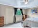 This bedroom has neutral-colored walls, a ceiling fan, and a window with black curtains at 431 N Harlan St, Lakewood, CO 80226