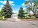 View of house and attached garage with long driveway surrounded by landscaping at 431 N Harlan St, Lakewood, CO 80226