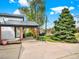 View of house with covered area, mature trees and landscaping at 431 N Harlan St, Lakewood, CO 80226