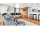 Open living area with hardwood floors, a rustic wood accent wall, and bar seating by the kitchen at 431 N Harlan St, Lakewood, CO 80226