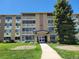 Building exterior with well-manicured lawn, walkway, and mature tree at 715 S Alton Way # 10A, Denver, CO 80247