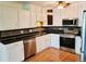 Updated kitchen features white cabinets, stainless steel appliances, and sleek black countertops at 715 S Alton Way # 10A, Denver, CO 80247