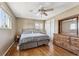 Bright bedroom with hardwood floors, a ceiling fan, and a window offering natural light and closet at 9430 Perry St, Westminster, CO 80031