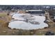 Aerial view of partially frozen community pond with bridge and geese, recreation center in background at 9430 Perry St, Westminster, CO 80031