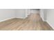 Large basement area with wood-look flooring, featuring an entry door and recessed lighting at 11791 Bradburn Blvd, Westminster, CO 80031