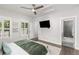 Bright bedroom with a view, featuring a ceiling fan, mounted TV, and an en-suite bathroom entrance at 11791 Bradburn Blvd, Westminster, CO 80031
