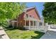 Beautiful red brick home with a covered porch and meticulously manicured lawn at 11791 Bradburn Blvd, Westminster, CO 80031