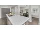 Bright, open kitchen with a large island, hardwood floors, and views into the dining area at 11791 Bradburn Blvd, Westminster, CO 80031