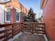 Small deck with wooden railings overlooking a tree and neighboring buildings at 65 N Logan St # B4, Denver, CO 80203