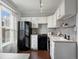 Modern kitchen with white cabinets, black appliances, and a gray countertop at 65 N Logan St # B4, Denver, CO 80203