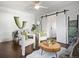 Inviting living room features white armchairs, modern sliding barn doors, and wood floors at 65 N Logan St # B4, Denver, CO 80203