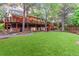 Lush backyard with green lawn, mature trees, and elevated wooden deck at 16416 E Powers Pl, Centennial, CO 80015