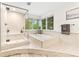 Modern bathroom featuring a soaking tub, glass shower, and a large window at 16416 E Powers Pl, Centennial, CO 80015
