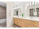 Bright bathroom with double vanity, wood cabinets, and a large mirror that reflects the light at 16416 E Powers Pl, Centennial, CO 80015