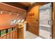 Hallway features wood-paneled walls, staircase with wood railing, and glass-enclosed shower at 16416 E Powers Pl, Centennial, CO 80015