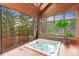 Relaxing indoor hot tub featuring wood paneled walls, large windows and a sliding door to a deck overlooking the trees at 16416 E Powers Pl, Centennial, CO 80015