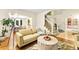 Open-concept living room with hardwood floors, a modern couch, and a staircase in the background at 16416 E Powers Pl, Centennial, CO 80015