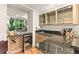 Modern wet bar with beverage cooler, sink, granite countertop, and glass shelving at 16416 E Powers Pl, Centennial, CO 80015