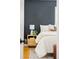 Cozy bedroom featuring a nightstand with lamp, plant and an accent wall at 9000 W 4Th Pl, Lakewood, CO 80226