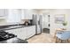 Updated kitchen with stainless steel appliances, white cabinets, and a dining area at 9000 W 4Th Pl, Lakewood, CO 80226