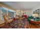 Bright living room with hardwood floors, patterned rug, and large picture window at 3831 S Hillcrest Dr, Denver, CO 80237