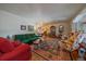 Bright living room with hardwood floors, patterned rug, and comfortable seating at 3831 S Hillcrest Dr, Denver, CO 80237