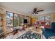 Sunroom filled with natural light, featuring a ceiling fan, comfortable seating, and large windows overlooking the yard at 3831 S Hillcrest Dr, Denver, CO 80237