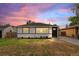 Charming single-story home with a well-maintained lawn and a lovely sunset backdrop at 742 Hanover St, Aurora, CO 80010
