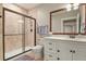 Well-lit bathroom with tiled shower, vanity, and modern fixtures at 7947 Monarch Rd, Larkspur, CO 80118