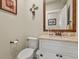 Powder room with a stone countertop vanity, decorative mirror, and a neutral color scheme at 7947 Monarch Rd, Larkspur, CO 80118