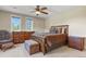 Comfortable bedroom features stylish wooden furniture, ceiling fan and bright windows at 7947 Monarch Rd, Larkspur, CO 80118