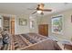Comfortable bedroom features stylish wooden furniture, ceiling fan and bright windows at 7947 Monarch Rd, Larkspur, CO 80118