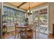 Bright dining area with wood floors, modern light fixture, and lovely backyard views at 7947 Monarch Rd, Larkspur, CO 80118