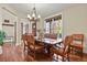 Elegant dining room with a classic chandelier, wood floors, and a view to the front yard at 7947 Monarch Rd, Larkspur, CO 80118