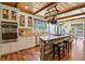 Spacious kitchen featuring wood beams, a large center island with seating, and stainless steel appliances at 7947 Monarch Rd, Larkspur, CO 80118