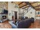 Spacious living room with a stone fireplace, hardwood floors, high ceilings, and a staircase at 7947 Monarch Rd, Larkspur, CO 80118
