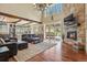 Open concept living room with a stone fireplace, hardwood floors, and access to outdoor patio at 7947 Monarch Rd, Larkspur, CO 80118