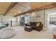 Cozy living room featuring a beamed wood ceiling, comfortable seating, and natural light from the windows at 7947 Monarch Rd, Larkspur, CO 80118