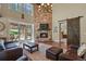 Cozy living room with a stone fireplace, large windows, and sliding door to the outdoor area at 7947 Monarch Rd, Larkspur, CO 80118