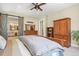 Spacious main bedroom with walk-in closet, ceiling fan, and rustic sliding barn door to bathroom at 7947 Monarch Rd, Larkspur, CO 80118