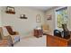 Inviting home office with comfortable seating and natural light streaming through the window at 7947 Monarch Rd, Larkspur, CO 80118