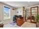 Comfortable office with natural light, wooden desk, and glass doors to dining area at 7947 Monarch Rd, Larkspur, CO 80118