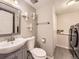 Bathroom with modern sink, toilet, towel bar, decorative shelves and in-unit laundry at 17404 E Prentice Cir, Centennial, CO 80015