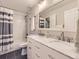 Bathroom featuring marble countertops, dual sinks, and a subway-tiled shower with a modern design and a spacious feel at 17404 E Prentice Cir, Centennial, CO 80015