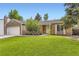 Charming ranch-style home with a lush green lawn, mature trees, and a two-car garage at 17404 E Prentice Cir, Centennial, CO 80015
