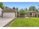 Well-maintained ranch house featuring a green lawn, mature tree, and a convenient two-car garage at 17404 E Prentice Cir, Centennial, CO 80015