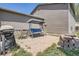 Relaxing back patio area with a swing, grill, and brick fire pit, perfect for outdoor entertaining at 8438 Prairie Clover Way, Parker, CO 80134
