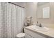 Clean bathroom with patterned shower curtain, mirrored cabinet, and essential toiletries on the sink at 8438 Prairie Clover Way, Parker, CO 80134